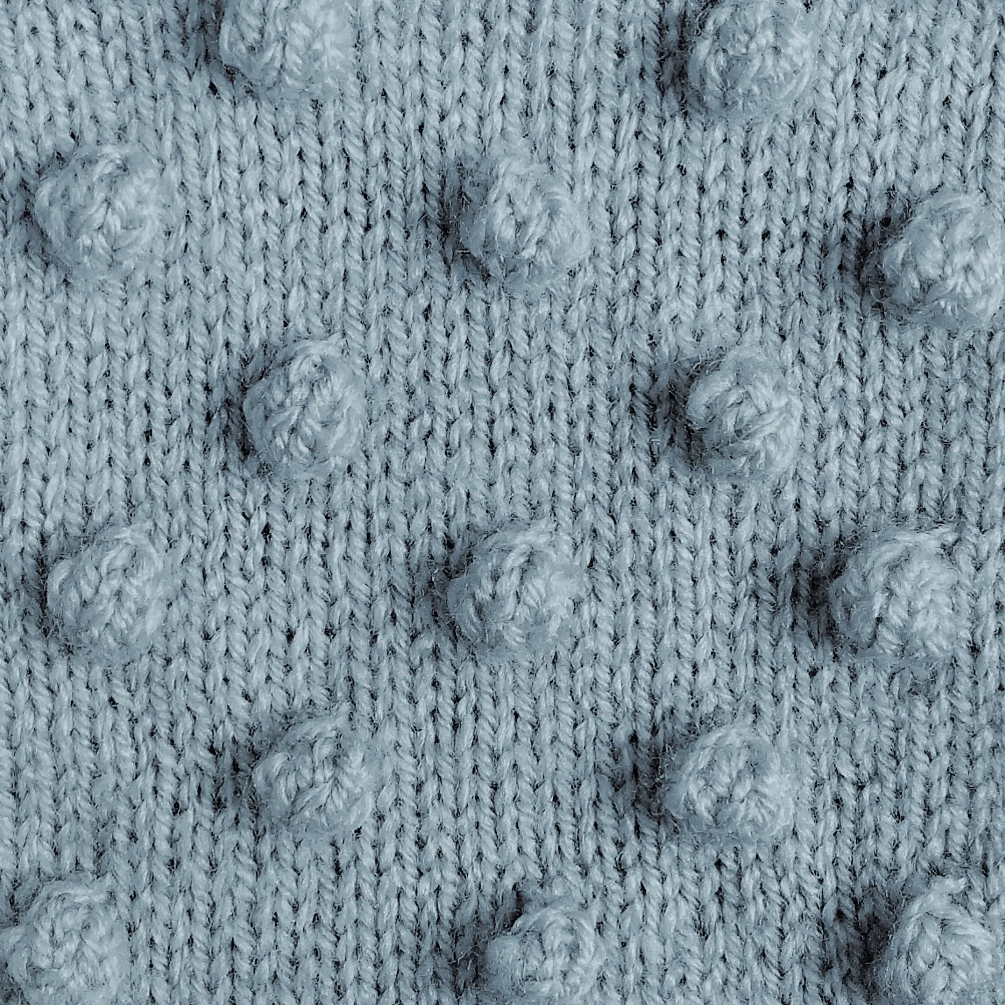 A swatch of knitting demonstrating the bobble stitch in light blue yarn Knit by KnitQ