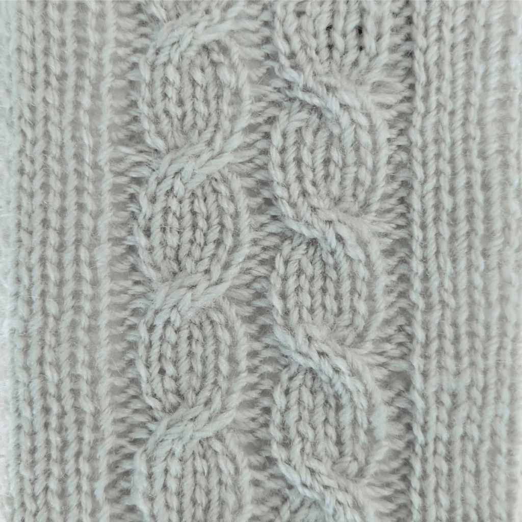 close up view of left-leaning and right-leaning knit cables