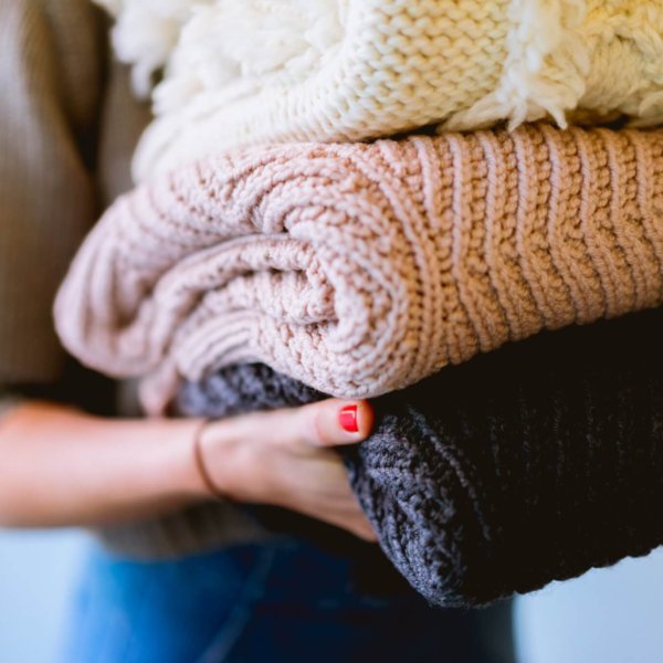 a close-up photo of a pile of sweaters for the Knitwear Care 101 article