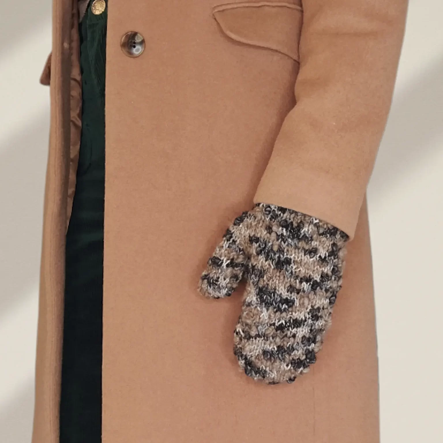 Thick and thin mittens worn with hands at side with camel coat