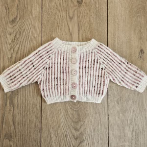 The marionberry newborn cardigan laid flat and buttoned on a wood backdrop