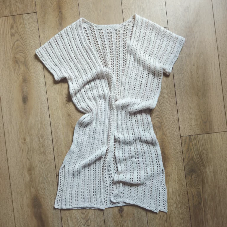 The Reya Swimsuit Cover-up laid out on a wood floor with some gentle wrinkles to show the drape
