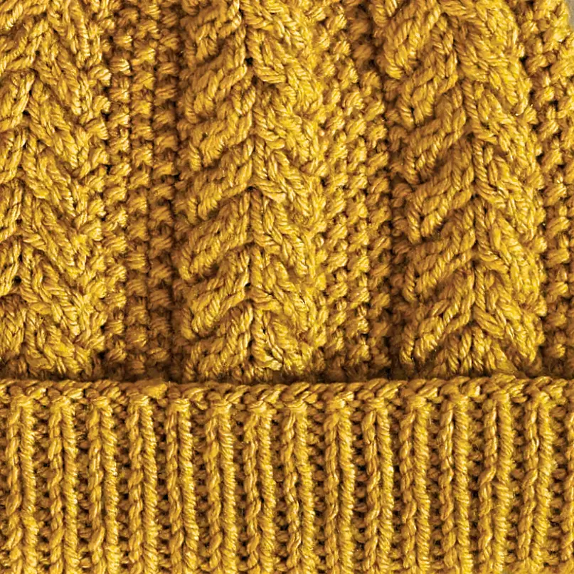 a close-up view of the rusk beanie showing the cables, seed stitch, and ribbing.