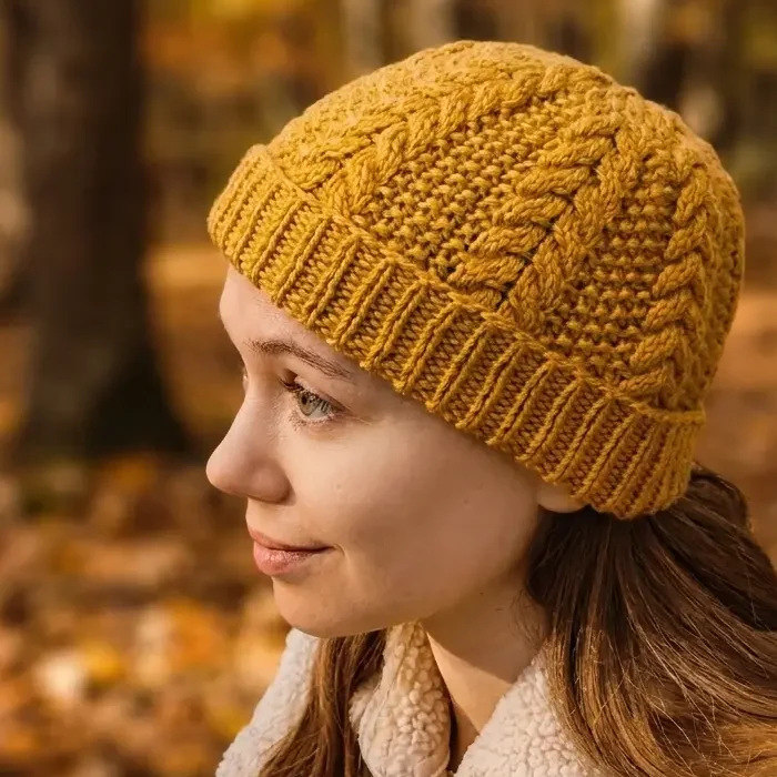 A picture of the rusk beanie being worn in front of a fall backdrop